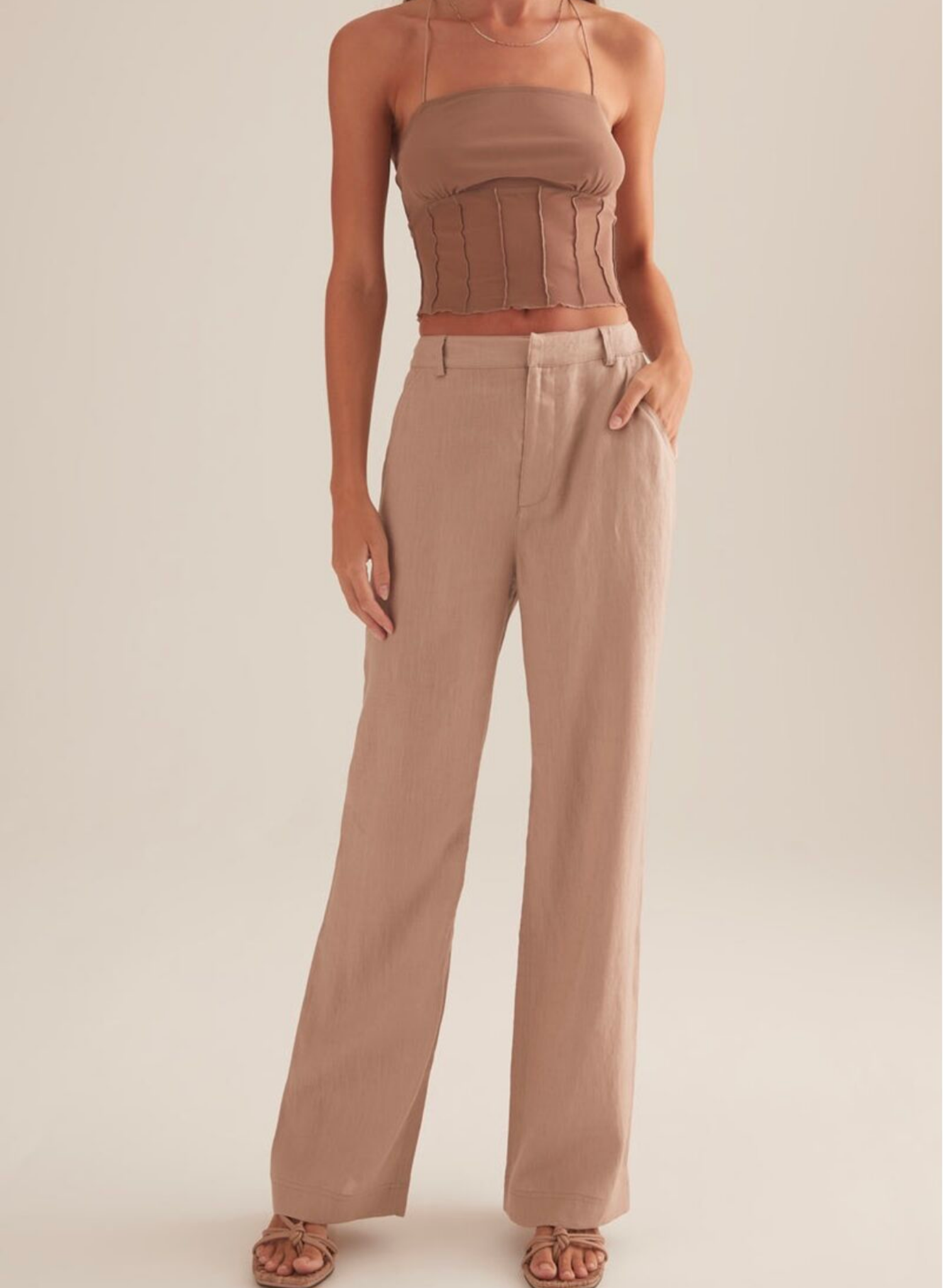The Charmed top, cut in Stone colour way. A cropped mini top with spaghetti straps and vertical paneling under the ruched bust.