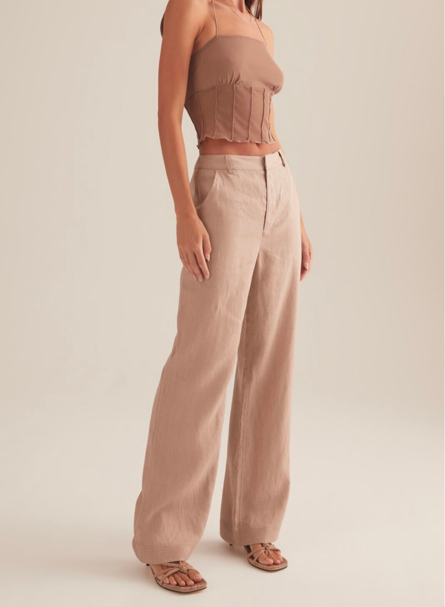 The Charmed top, cut in Stone colour way. A cropped mini top with spaghetti straps and vertical paneling under the ruched bust.