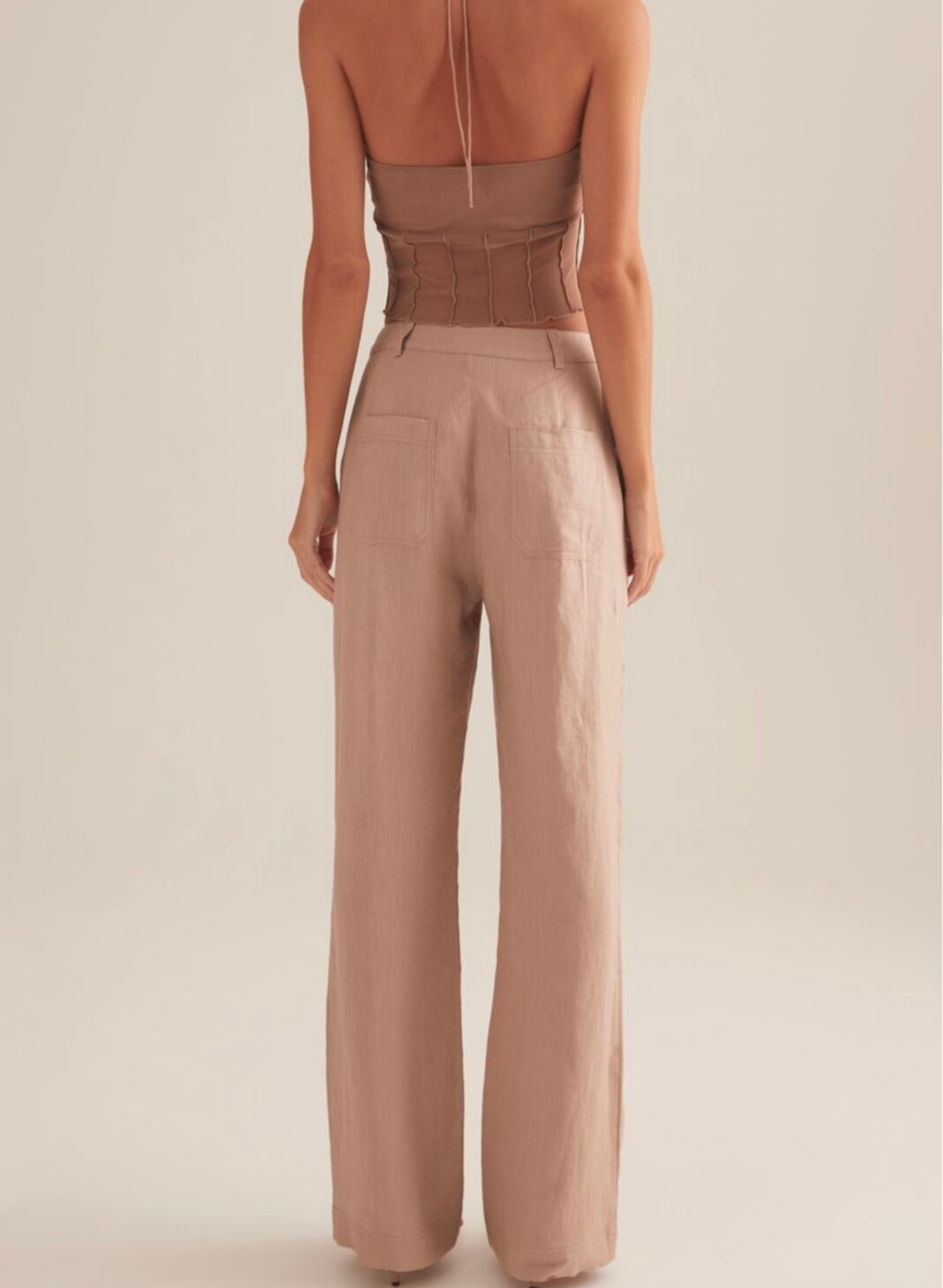 The Charmed top, cut in Stone colour way. A cropped mini top with spaghetti straps and vertical paneling under the ruched bust.
