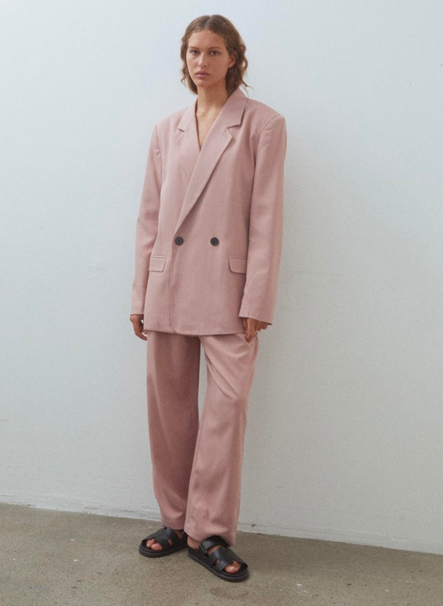 Introducing the Dana in Dusty Pink, a double-breasted suit jacket with charming lapels. This outerwear piece takes notes from men’s tailoring with considered darts for definition at the waist.