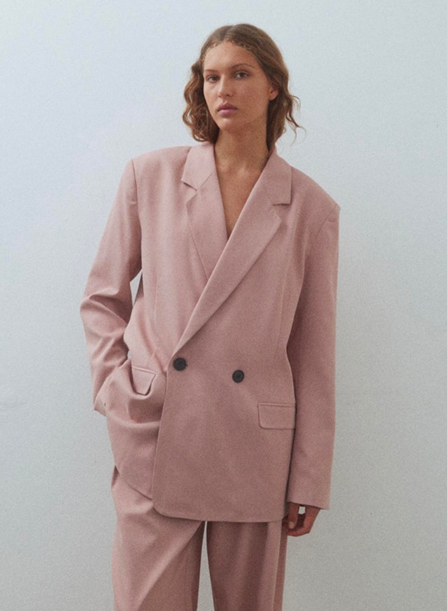 Introducing the Dana in Dusty Pink, a double-breasted suit jacket with charming lapels. This outerwear piece takes notes from men’s tailoring with considered darts for definition at the waist.