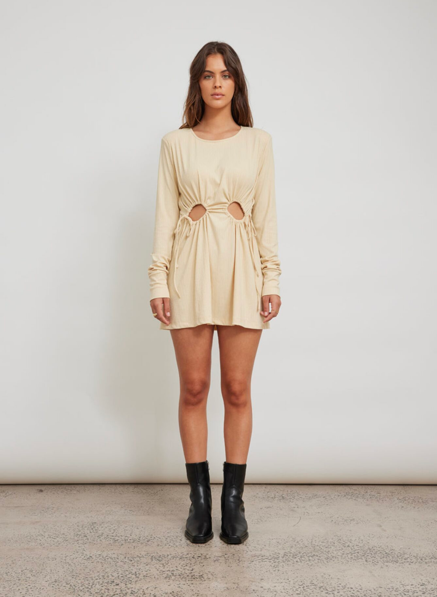 Long sleeve mini dress Mini shoulder pads Double cut out detail at front waist with adjustable drawstrings Soft rubbed jersey fabrication Dress is lined