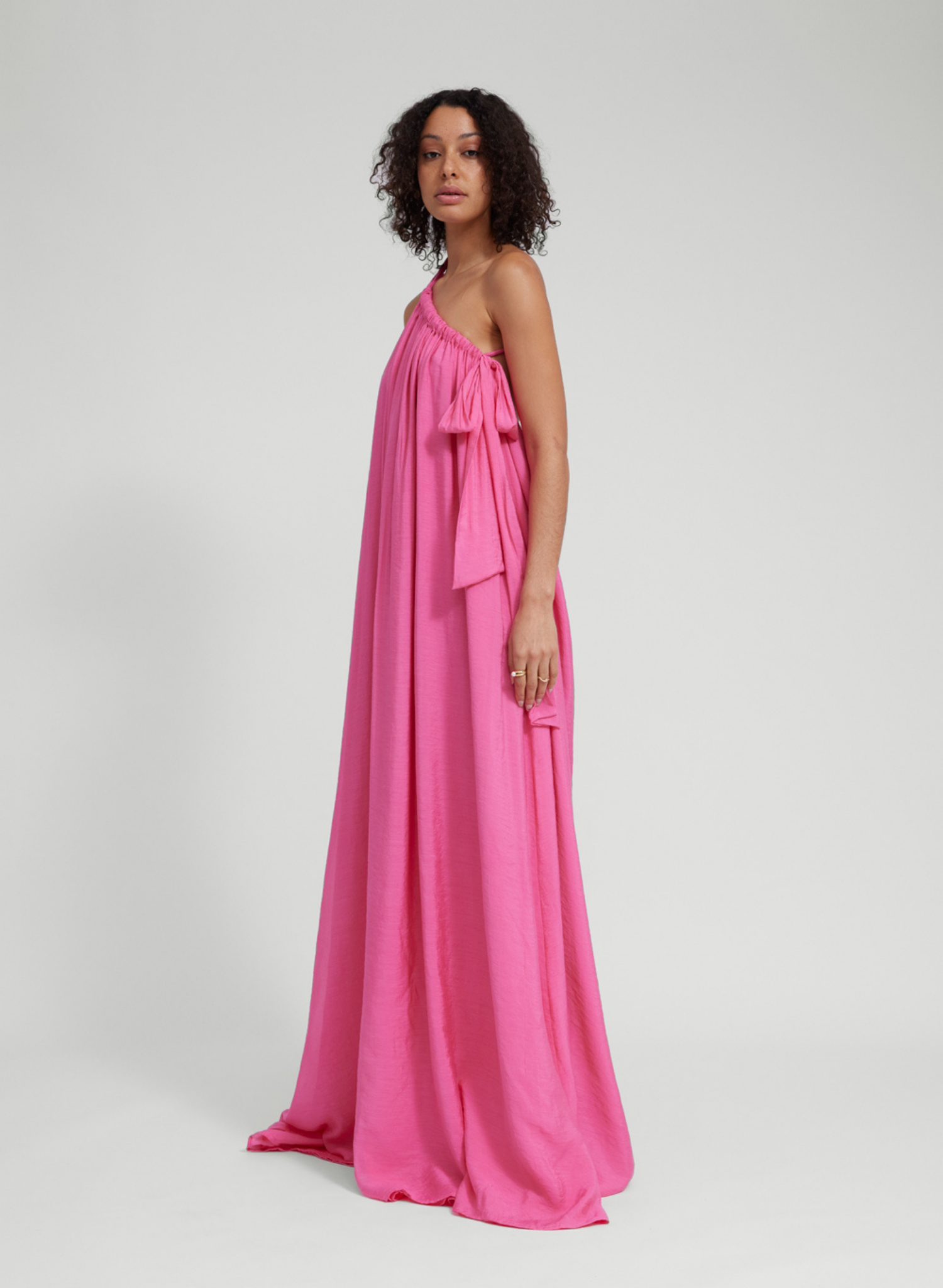 Floor length lightweight gown Adjustable strapping detail with ties Dress features 3 layers of main sheer fabric, to create pastel opaque appearance. Low back Fit adjustability through halter and shoulder strapping