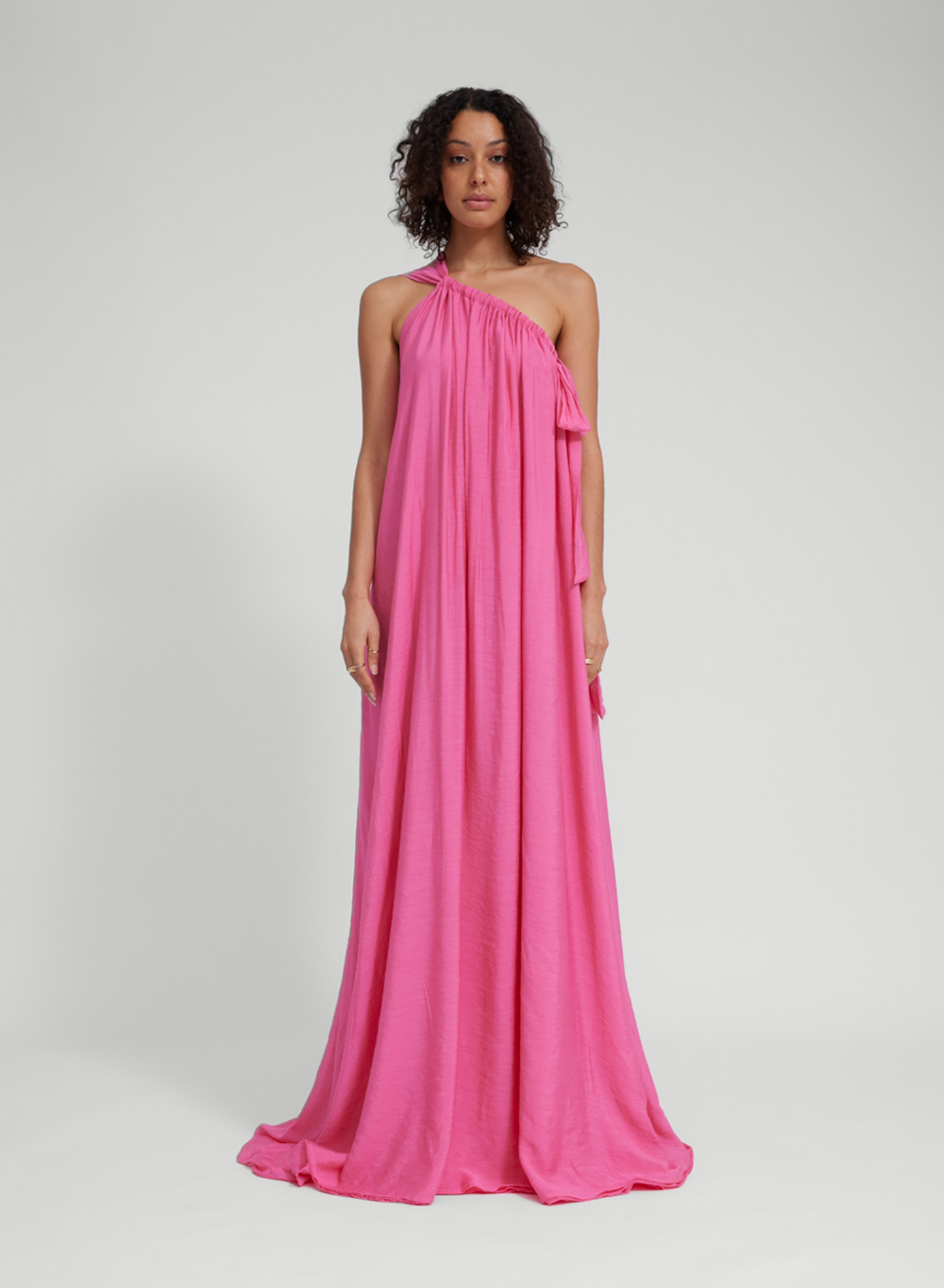 Floor length lightweight gown Adjustable strapping detail with ties Dress features 3 layers of main sheer fabric, to create pastel opaque appearance. Low back Fit adjustability through halter and shoulder strapping