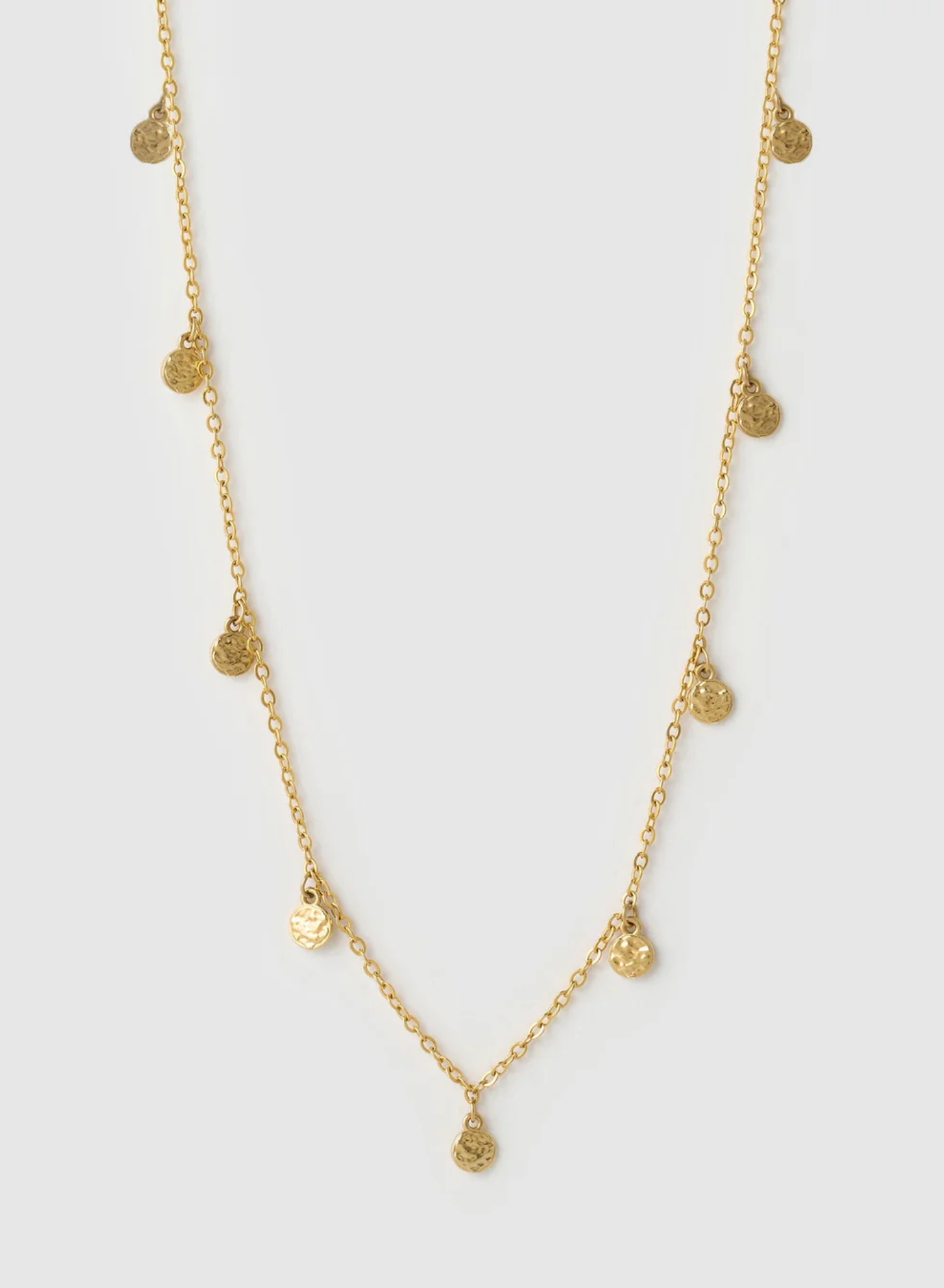 Gold necklace with small heart-shaped pendants on a light gray background